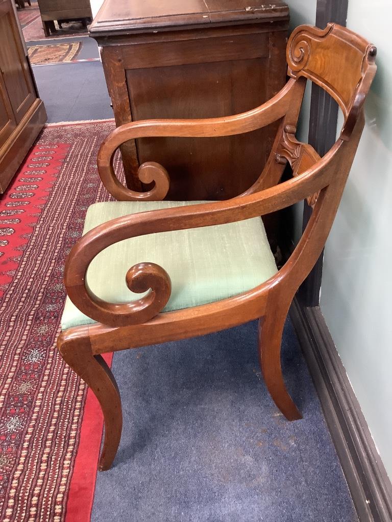 A set of six George V mahogany sabre leg dining chairs (two with arms)